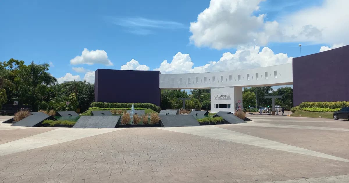Entrada principal de Residencial Cumbres en Cancún, con fuente, jardines y caseta de vigilancia